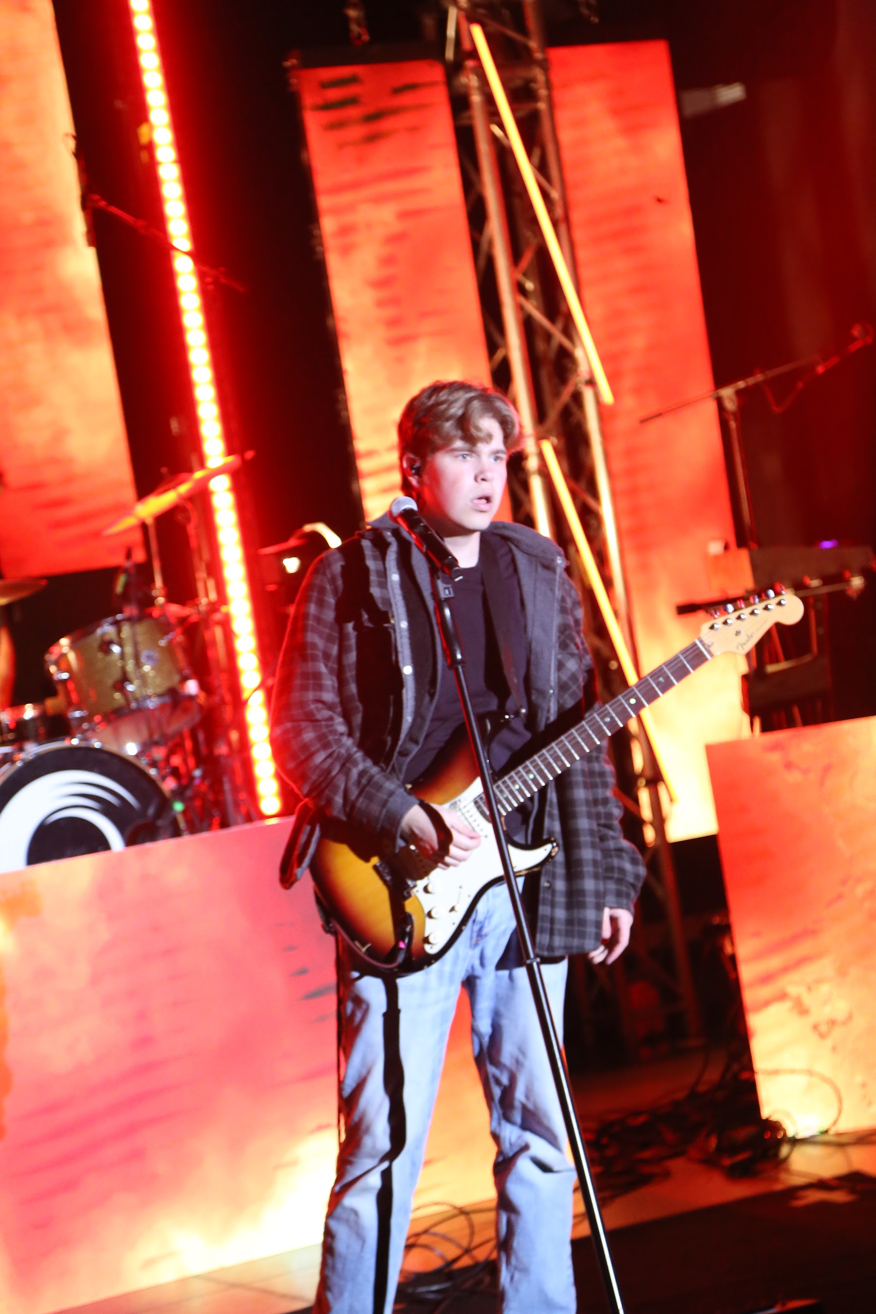 Guitarist under red stage lighting
